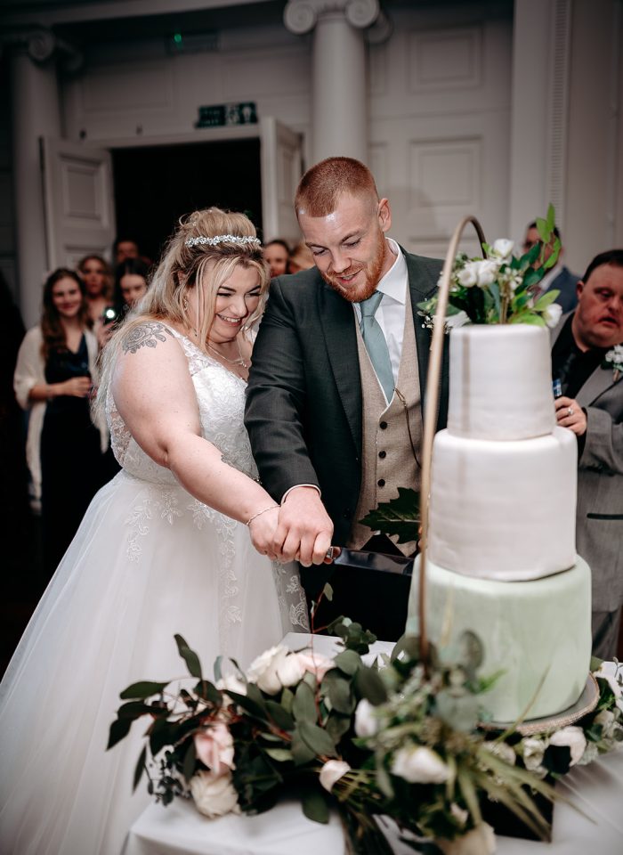 Kayleigh & Adam Willets Bride and groom cutting cake surrounded by guests at Rowton Castle