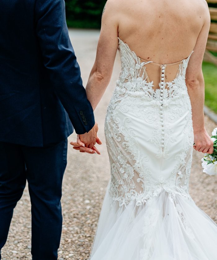 Natural wedding photo of couple walking hand in hand through west midlands wedding venue - how far in advance to book wedding photographer