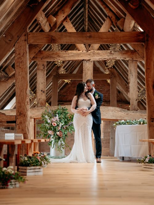 Bride and Groom walking through the fields candid wedding photography - shropshire wedding venue Moat House Barns